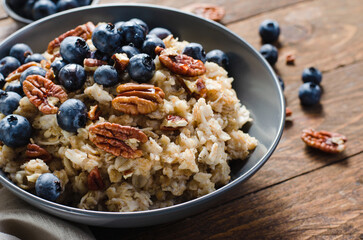 Oatmeal Bowl, Oat Porridge with Blueberry and Pecans in a Bowl on Rustic Background, Healthy Snack or Breakfast
