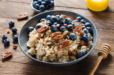 Oatmeal Bowl, Oat Porridge with Blueberry and Pecans in a Bowl on Rustic Background, Healthy Snack or Breakfast