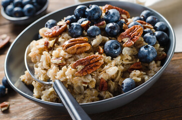 Oatmeal Bowl, Oat Porridge with Blueberry and Pecans in a Bowl on Rustic Background, Healthy Snack or Breakfast