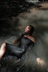 Fototapeta na wymiar Art beautiful romantic woman lies in dress at the river
