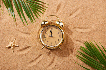 Alarm clock on a sandy beach. Noon, 12 p.m. A dangerous time for tanning and being in the sun.Sand...