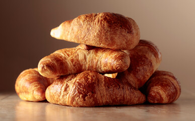 Freshly baked croissants on a beige ceramic table.