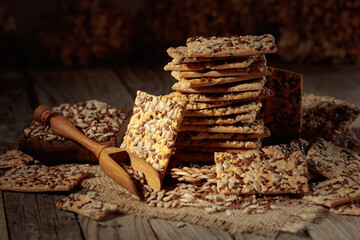 Crackers with sunflower and flax seeds on an old wooden table.