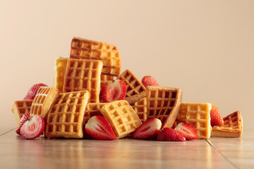 Belgian waffles with strawberries on a beige background.