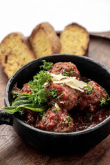 italian traditional beef meatballs with tomato sauce on wood board
