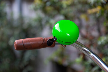 Fototapeta na wymiar Green gremlin bell on a bike handlebar