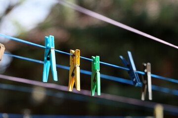 Kolorowe spinacze do prania wiszą na sznurku do suszenia. 
