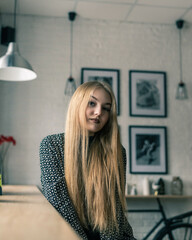 Portrait of a young beautiful blonde girl in a retro cafe.