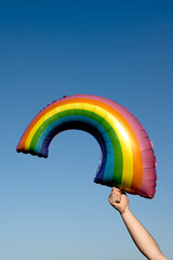 man grabbing a rainbow balloon