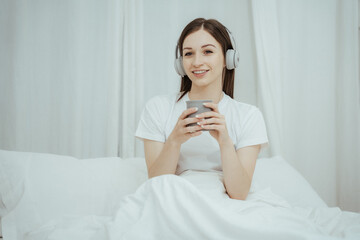 Beautiful girl at her bedroom drinking tea in the morning.