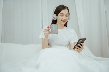 Beautiful girl at her bedroom drinking tea in the morning.