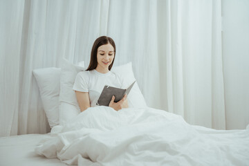 Obraz premium Happy woman holding apple and listening to music sitting on sofa in living room at home