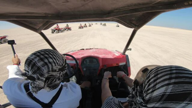 EDITORIAL GO PRO???? POV - tourists with face scarfs fast driving a buggy, atv in the safari desert in Egypt