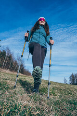 Woman with backpack hiking in remote sunny rural field. 