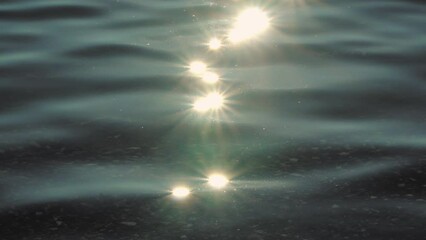 Sun light reflecting or sparkling glitter on water of sea or ocean