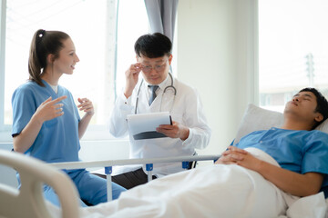 Obraz premium Friendly professionals doctor and nurse taking care of patient man in a hospital room. Treatment of patients.