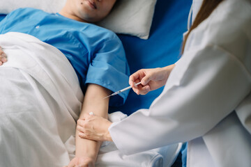 close-up of doctor injecting patient with syringe to collect blood.