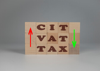 Zmiana podatku VAT, CIT, podwyżka, obniżka. Klocki z napisem i strzałkami Tax VAT, CIT.