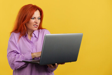 Mature redheaded woman having a problem with a laptop