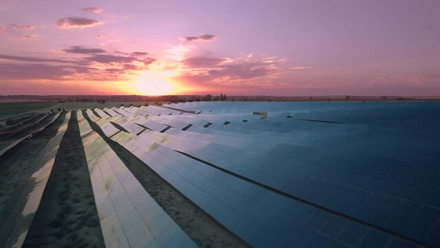 Elevated view (close-up) of the solar power plant with sunset reflection on the solar panels. The evening sun shines on the solar panels. Renewable Energy, Solar Energy, Spain