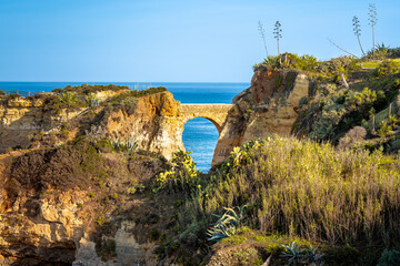 Ponte Romana de Lagos, an ancient Roman bridge, connects two cliffs over the Students Beach, with...