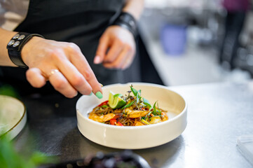 Chef cooking Stir fry noodles with vegetables and shrimps on restaurant kitchen