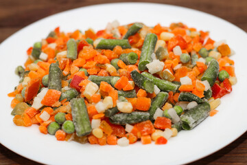 Frozen vegetables carrots, peas, beans in a plate.