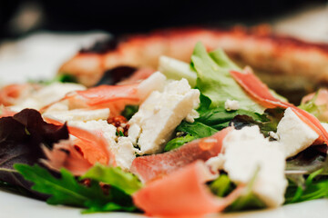 Salad with feta cheese with arugula and fried sausage.