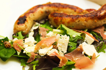Salad with feta cheese with arugula and fried sausage.