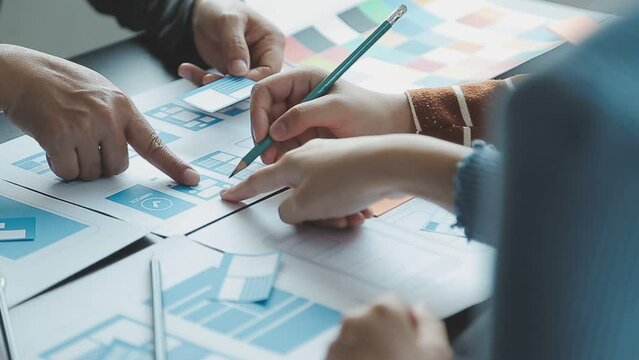 Close up ux developer and ui designer brainstorming about mobile app interface wireframe design on table with customer breif and color code at modern office.Creative digital development agency - Powered by Adobe