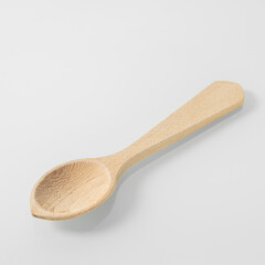 Wood kitchen utensils. Wooden tea spoon on a white mirror background