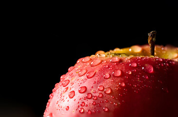 Macro red apple in water drops with blurry background.