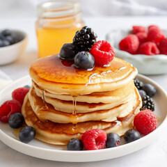 A stack of fluffy pancakes with fresh fruit and maple syrup 