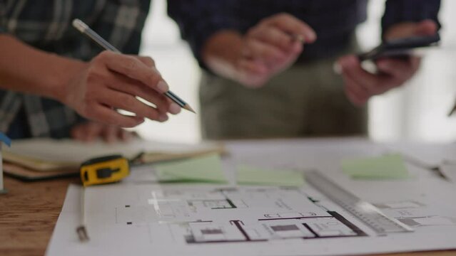 Closeup of hands engineer and architect team discussed about construction and architectural drawings works.