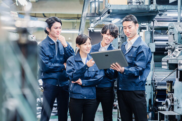 タブレット端末を見ながら会議をする工場スタッフ