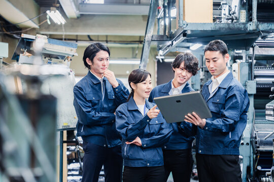 タブレット端末を見ながら会議をする工場スタッフ