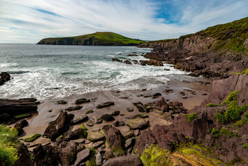 Naklejka na ściany i meble Rocky beach of Beenbane, Dingle lighthouse in the distance, Dingle Peninsula, County Kerry, Ireland