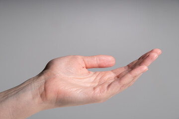 Closeup of human open hand palm on grey background