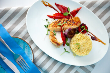 Grilled chicken fillet and vegetables. Bulgur porridge. Couscous on a white plate. Useful healthy food. Roasted peppers, onions, greens and microgreens. Meat and vegetable top view background.