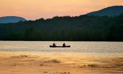 Silhouette of two people in a canoe at sunset