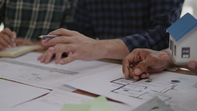 Closeup of hands engineer and architect team discussed about construction and architectural drawings works.