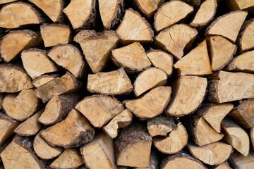 Pile of firewood stocked outdoors, in close up