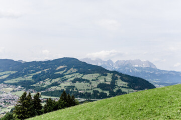 Fototapeta na wymiar Aussicht auf eine Berglandschaft vor blauem Himmel und grünen Wiesen