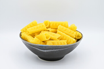 Festonati pasta in a dark grey bowl, isolated on a white background
