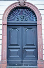 Old, decorated wooden door with architectural elements in Frankfurt, Germany