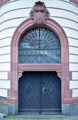 Old, decorated wooden door with architectural elements in Frankfurt, Germany
