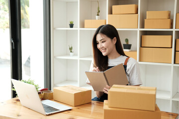 A female entrepreneur selling clothes and checking orders from customer for online shopping concept