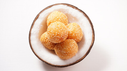 Thai dessert sesame balls stuffed with fried mung beans in a coconut shell