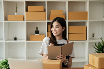 Fototapeta na wymiar Asian SME business woman working at home office. online shopping concept