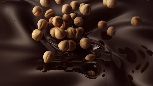 hazelnuts pouring into liquid dark chocolate ice cream mixture